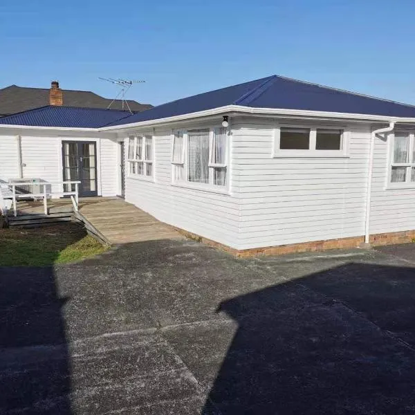 White weather board house, hotel v Aucklandu