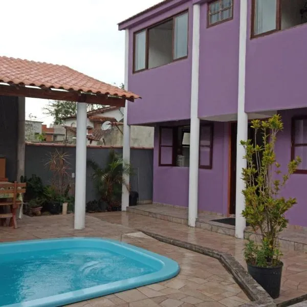 Casa roxa com piscina em condomínio