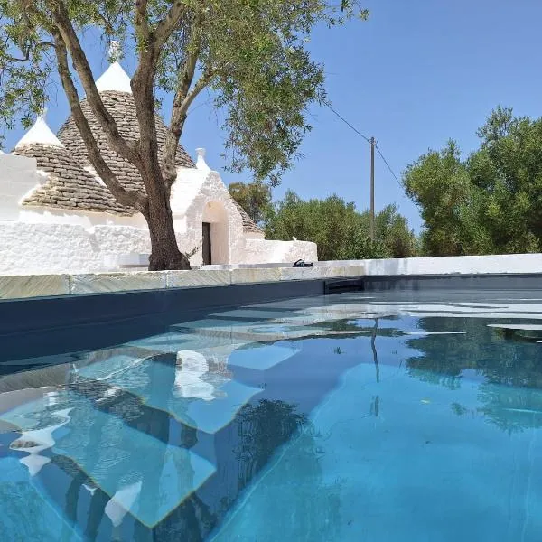 Trulli au milieu d'un champ d'oliviers avec piscine