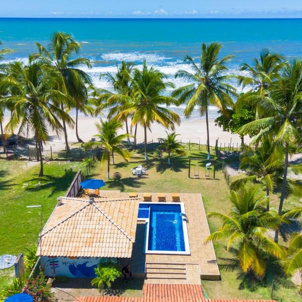 Casa completo com grande piscina sob coqueiros, pe na areia