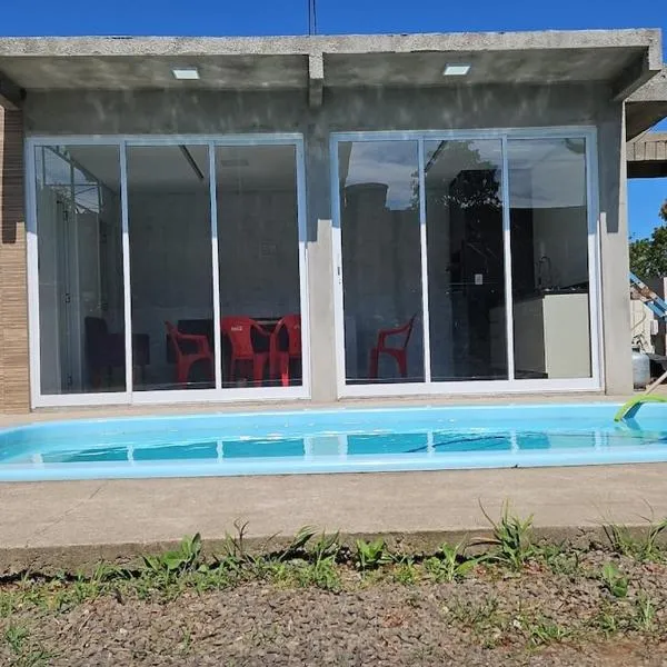 Casa com três quartos, piscina e área Gourmet, hotel em Torres