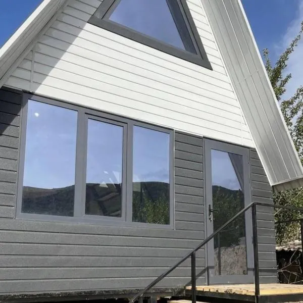 A frame house with a view of mountains, hotel in Karakol