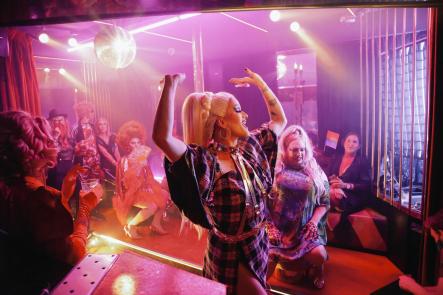 Un gruppo di persone si diverte tra balli e drink in discoteca.